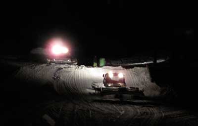 Snow groomers at night