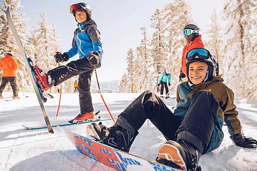 Skier and boarder kids stopped on trail